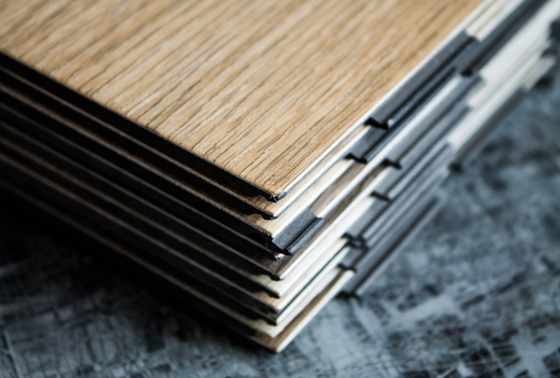 A close-up of a stack of wood-effect LVT flooring